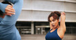 © FantiS/peopleimages.com - Fitness, arm warm up and women in city with workout or training for wellness, health or activity. Sports, stretching and female athletes with exercise together in urban town for weightloss in morning