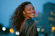 © Papukos - Beautiful model smiling with city lights in background at dusk