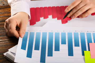 Fototapete - Woman with pen and business charts working at table in office, closeup