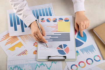 Fototapete - Woman with pen and business charts working at table in office, closeup