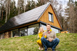 © Westend61 - Happy father and daughter sitting in front of modern house near forest