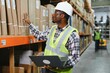 © Serhii - Portrait of a handsome african american warehouse worker in overalls and a helmet