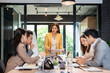 © Fahng - Young business woman executive ceo leader discussing project management planning strategy working with diverse colleagues company team at office corporate board group meeting.