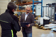 © bnenin - Manager Discussing Warehouse Operations with Worker in Industrial Setting