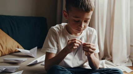 Poster - Concentrated pupil carefully folds a paper airplane, surrounded by other completed planes, showcasing the art of origami and the joy of creation