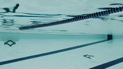Poster - Ripples and reflections create mesmerizing patterns on the turquoise water surface, providing a serene backdrop to the lane ropes and markings on the pool floor