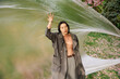 © LIGHTFIELD STUDIOS - Stylish young man in grey outfit poses creatively in a vibrant park setting