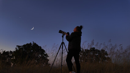 Wall Mural - amateur astronomer using camera and lens for photographing stars, moon, planets and other celestial 