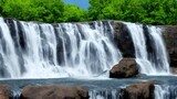 Cascade flowing over rocks in a beautiful green forest landscape