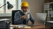 © Fahrudin - Focused Construction Professional Sipping Coffee While Working on Laptop