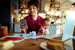 © Davor - Work from home mom with baby on video call in kitchen