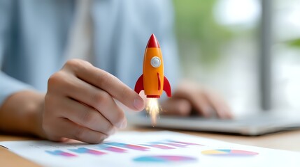 Poster - Orange rocket with flame trail held over business charts and graphs on desk, symbolizing startup growth and business success metrics analysis.