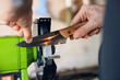© New Africa - Man sharpening knife with bench grinder indoors, closeup