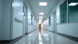 © Curioso.Photography - A long, blurred hospital corridor with a bright light at the end conveys a sense of depth and a clinical, futuristic atmosphere.