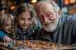 © Dennis - Elderly man playing board games with grandchildren
