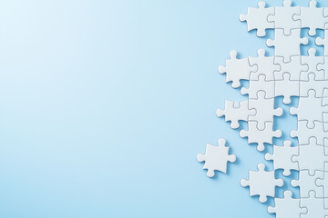 Poster - White puzzle pieces scattered on light blue background create serene and calming atmosphere, perfect for conveying themes of problem solving and creativity