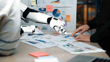 Poster - A robotic arm collaborates with a human in an office setting, analyzing business metrics and data presented through colorful graphs and reports to enhance productivity.Noogenesis