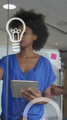 Poster - Animation of bulb icons floating over african american male and female business colleagues in office