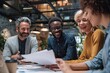 © Gamenin - Diverse team joyfully reviewing documents together at a modern office table, showcasing collaboration and success