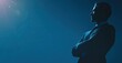 © Genshin - Silhouette of a man in a suit, arms crossed, gazing thoughtfully towards a bright light source against a deep blue background