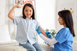 © Pixel-Shot - Happy little Asian girl receiving vaccine at hospital