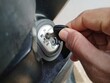 © tonekale - Close up a person turns on the ignition of a motorbike.