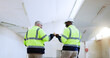 © FantiS/peopleimages.com - Men, architect and happy with fist bump, team and excited for results with building inspection. People, technician and engineer with goals, motivation and support with feedback at construction site