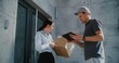 © Framestock - Postman Delivering Parcel Box for Recipient Working in Modern Office. Businesswoman Taking Package with Online Shopping Order, Signing POD on Tablet Computer. Delivery or Postal Service. Slow Motion.