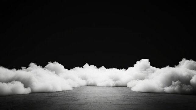 A monochrome image showcasing a layer of fluffy clouds against a stark black background and a gray floor