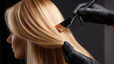 Blonde hair dying with brush and black gloves, close up of hair coloring process with smooth shiny hair strands