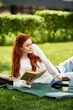 © Bliss - Young woman enjoying a relaxing reading session on a sunny day in the park outdoors