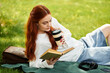 © Bliss - Enjoying a moment of relaxation with a book and coffee in a sunny park setting