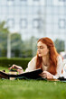 © Bliss - Young woman enjoying her spare time while writing in a notebook on a sunny day outdoors