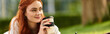 © Bliss - Young woman enjoying coffee while relaxing in a sunny park on a leisurely afternoon