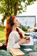 © Bliss - Relaxing afternoon with music and coffee in a sunny urban park setting by a young woman