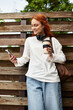 © Bliss - Enjoying a sunny afternoon with coffee while scrolling through the phone outdoors
