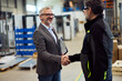 © bnenin - Professionals Shaking Hands in a Modern Industrial Facility Setting