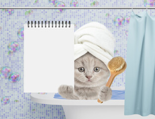 Aufkleber - Cute kitten with towel on it head takes the bath at home and shows blank notepad. Empty space for text