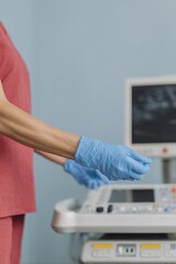 Poster - Medical professional wearing protective gloves preparing ultrasound probe for Doppler scan on modern diagnostic workstation in healthcare setting