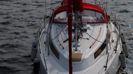 Aufkleber - A small white boat with a distinctive red bow floating on calm water