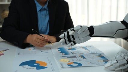 Poster - A unique collaboration between a human and a robot in an office setting, showcasing business charts and data analysis for strategic planning and decision-making.Noogenesis