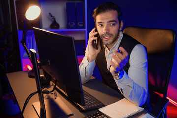 Poster - Smart businessman calling partner or investor on smartphone, discussing on target market database folder report to analyze sales channel discipline's product service at neon dark light room. Surmise.
