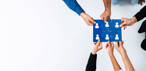 Aufkleber - A diverse group of hands working together to connect puzzle pieces, symbolizing teamwork and networking in a collaborative office environment. Amity
