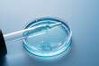 © ADDICTIVE STOCK - Cosmetic pipette in petri dish with blue liquid