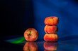 © ADDICTIVE STOCK - Stack of flat peaches on dark reflective surface