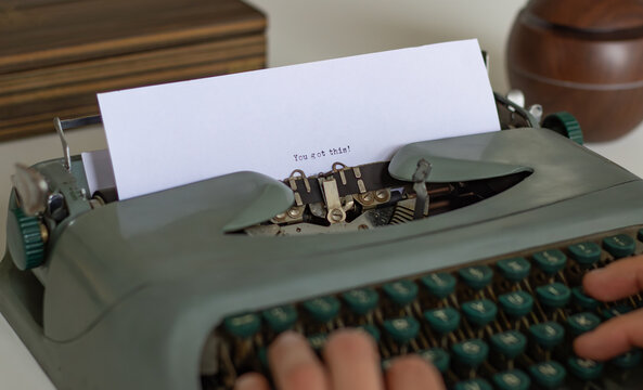 Close-up of a writer's hands typing the motivational phrase you got this on a vintage typewriter, conveying a message of encouragement and self-belief