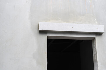 Poster - Concrete wall during house renovation shows an unfinished window and lintel. empty frame and raw material create hopeful mood for building project