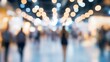 © Elite Holiday - Blurred people walking in a brightly lit space with bokeh lights creating a sense of movement and energy