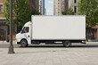 © Juninho - Photorealistic city street scene with a delivery truck featuring a blank white trailer, perfect for vehicle branding mockups. Urban background with buildings and light traffic in daylight.