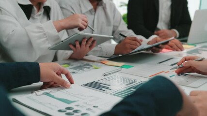 Poster - A business team engages in a strategic meeting, analyzing data and discussing ideas collaboratively in a modern office setting with digital devices and charts present. SACTR